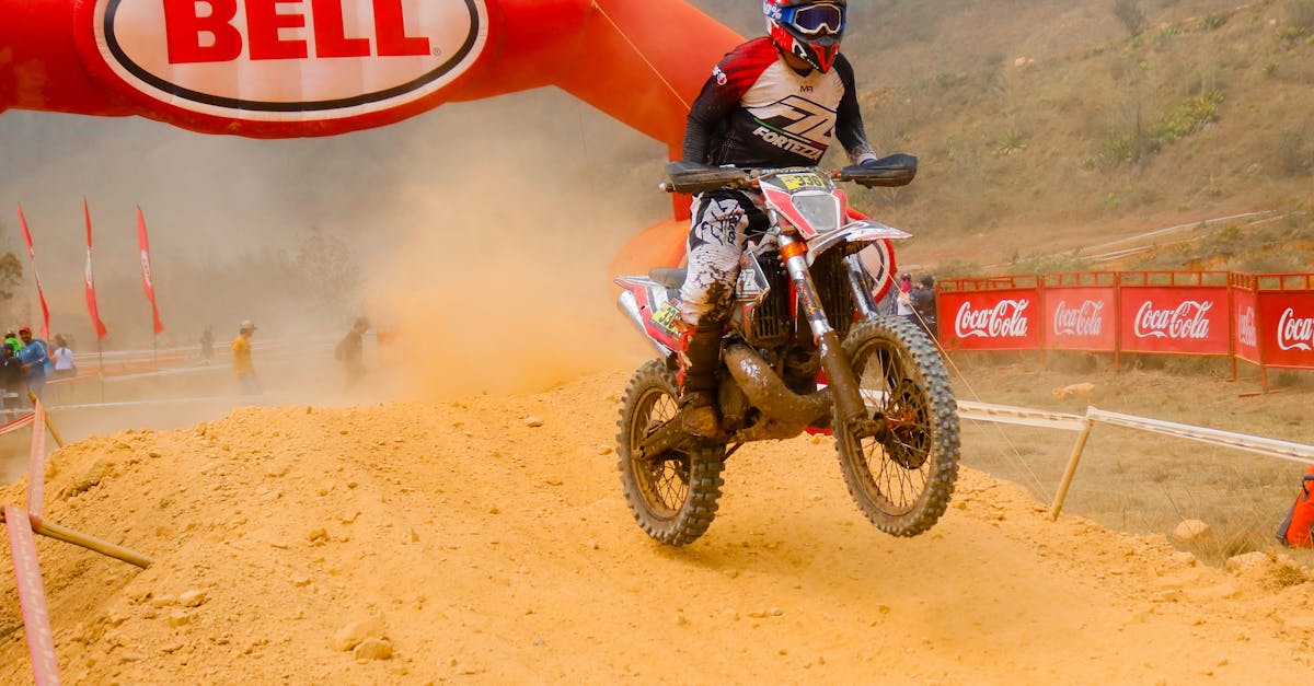 Dirt bike racer jumps on dusty track