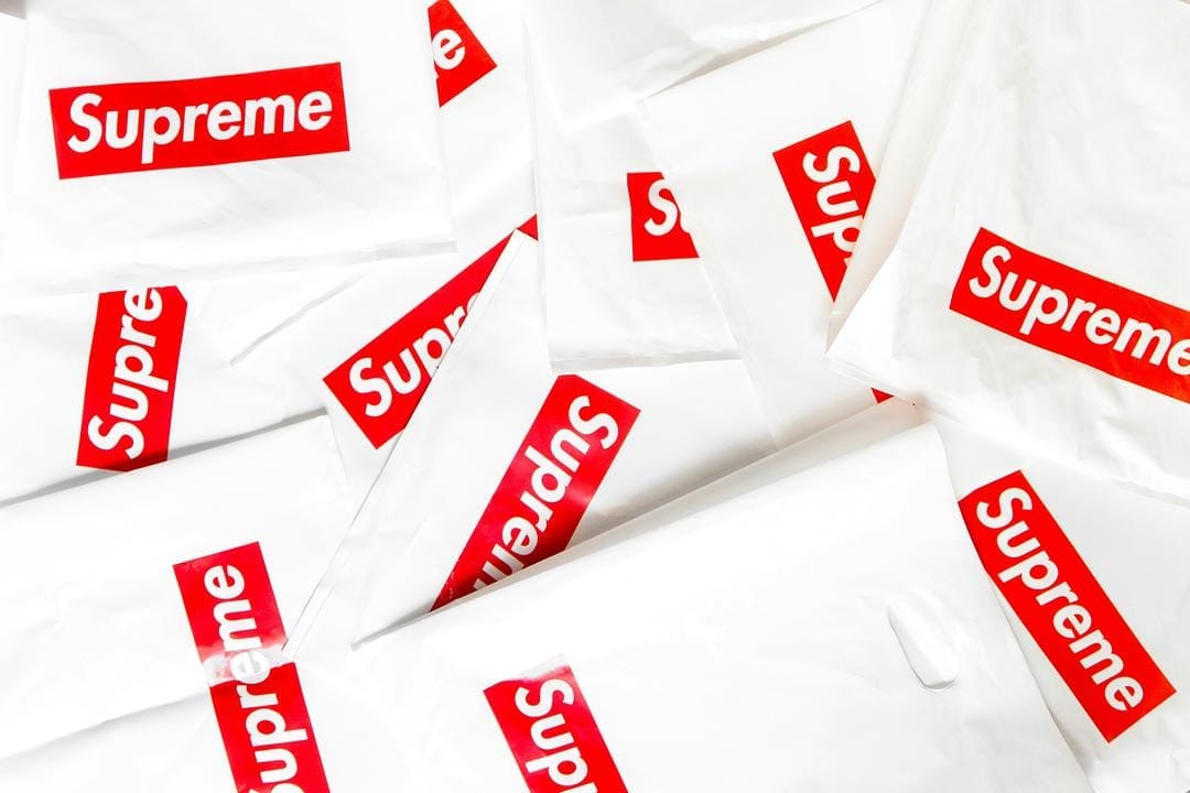 Multiple Supreme branded shopping bags on display.