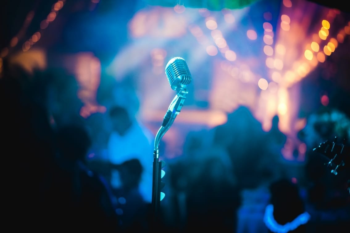 Microphone on stage with blurred lights background.