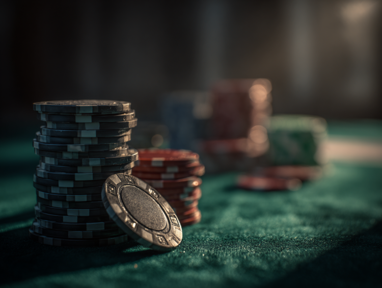 Stacked poker chips on casino table, blurred background.
