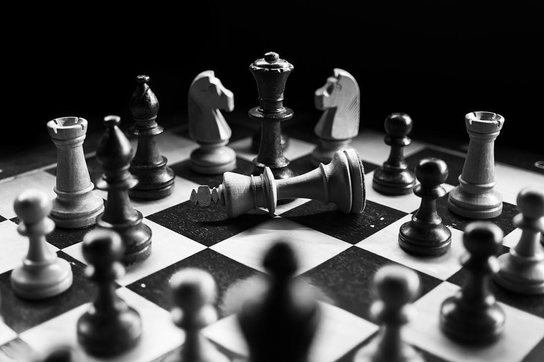 Checkmated king surrounded by chess pieces