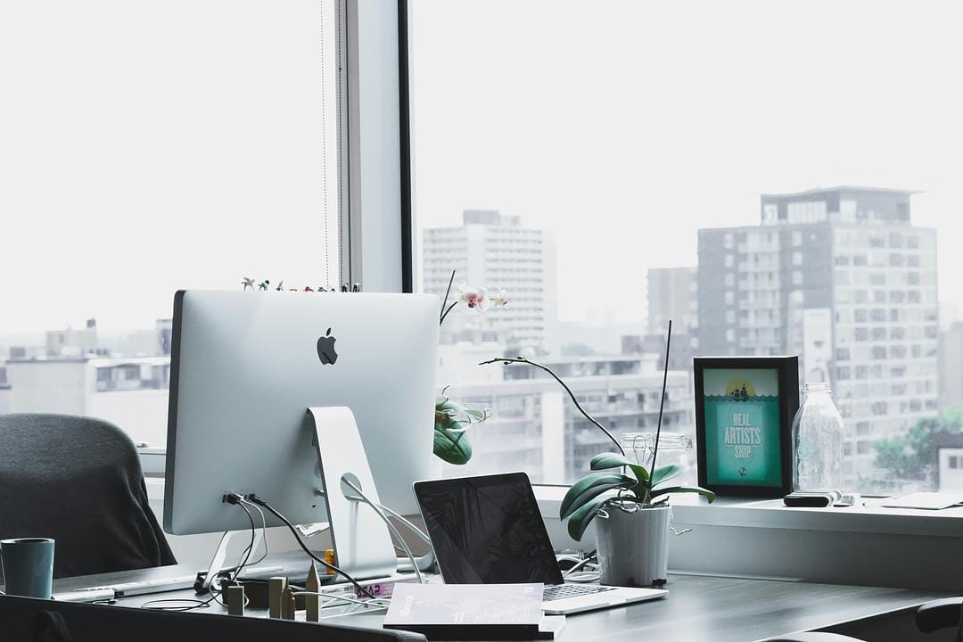 Modern office with computer overlooking cityscape.