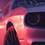 Close-up of sleek red sports car with raindrops.