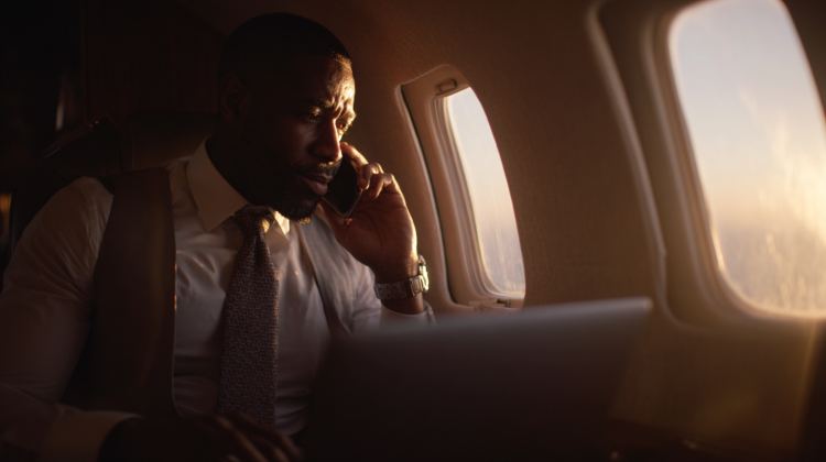 Man on phone in airplane talks business.