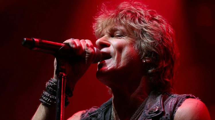 Singer performing passionately onstage with microphone.