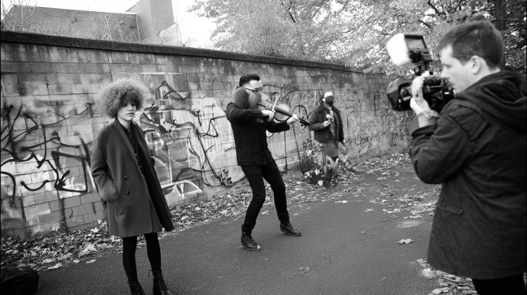 Street performance captured on camera with violinist.