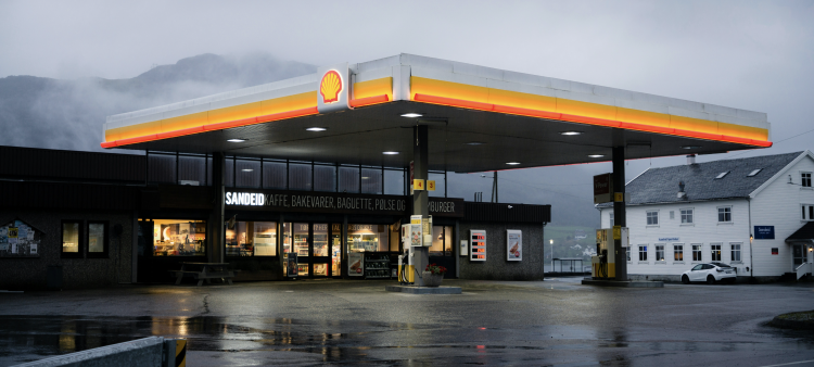 Shell gas station in foggy evening scene.