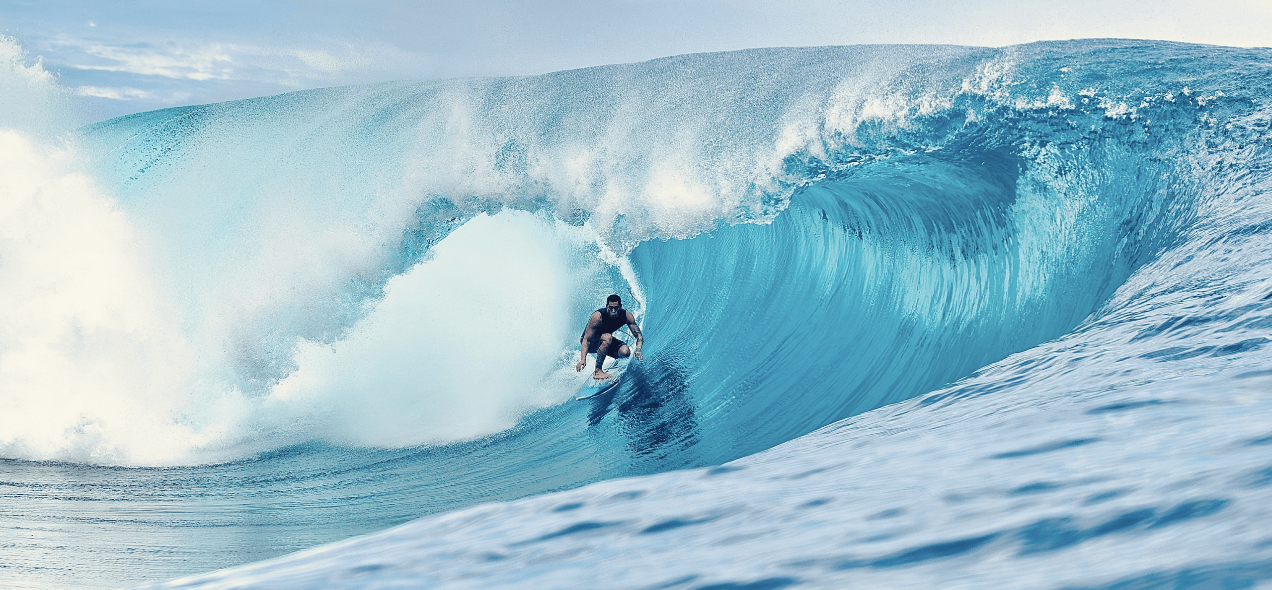 Surfer riding a large wave in the ocean.