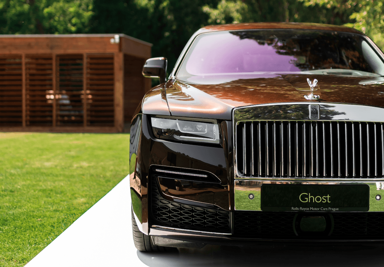 Luxury car in front of modern wooden building.