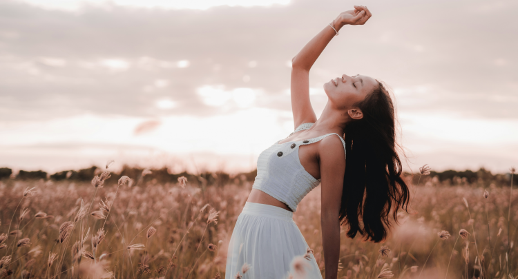 Woman enjoying sunset in a wheat field