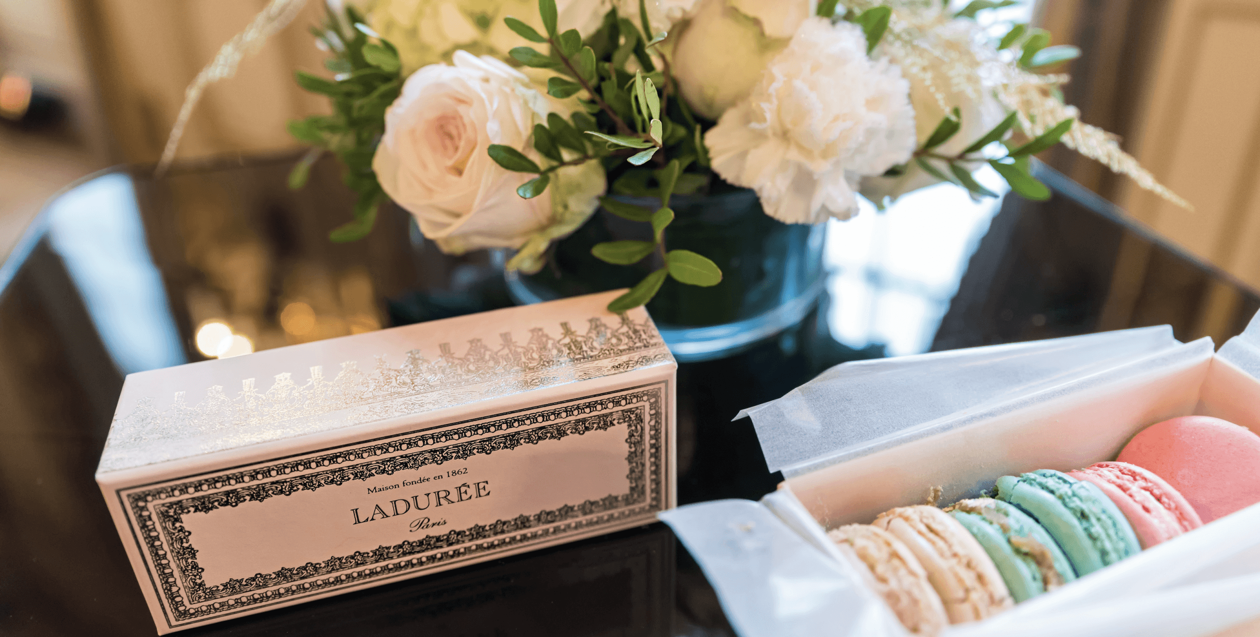 Laduree macarons and flowers on a table