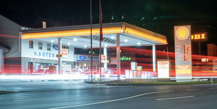 Shell gas station illuminated at night with price sign