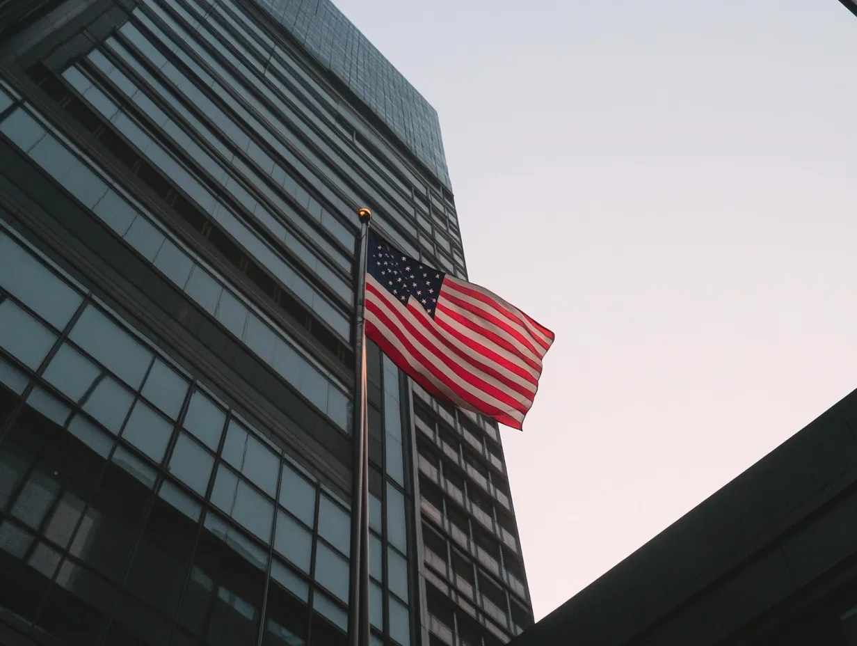 American flag flying in front of skyscraper