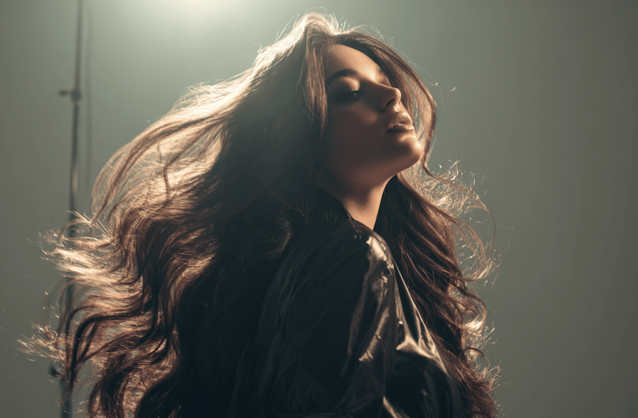 Woman with flowing hair in studio light.